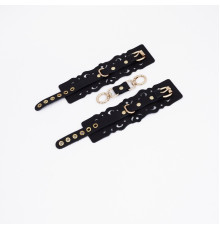 Черные кожаные наручники с узорами и золотистой фурнитурой