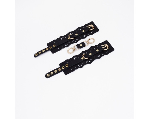 Черные кожаные наручники с узорами и золотистой фурнитурой