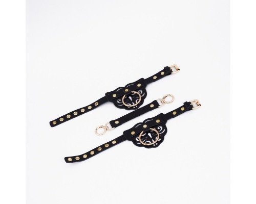 Черные кожаные оковы с резными узорами и клепками