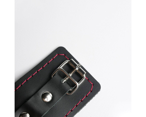 Черные кожаные наручники с красной строчкой